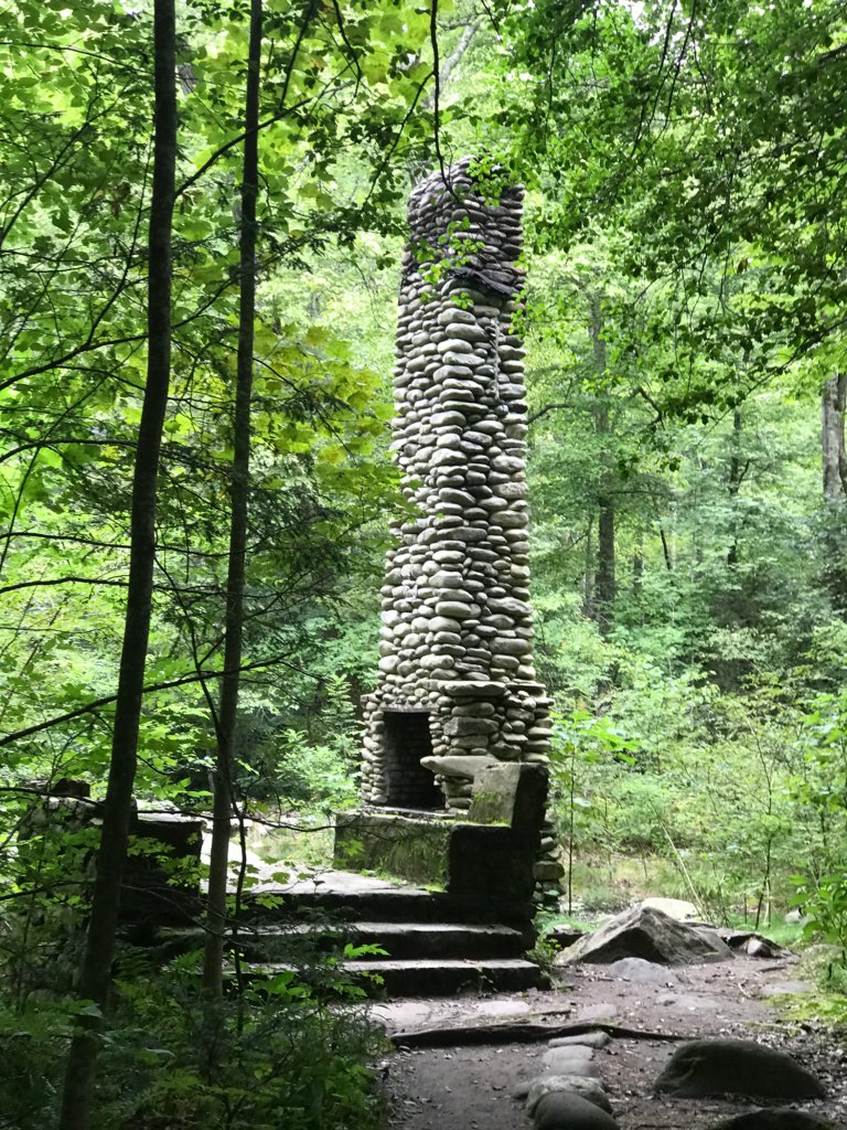 A stone tower in the woods  Description automatically generated with low confidence